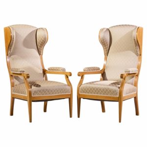 Pair of beige high-back upholstered armchairs with light wood frames facing each other.