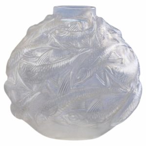Clear glass vase with an intricate raised fish pattern all over the surface.