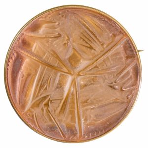 Copper coin featuring a faceted, starburst-like pattern radiating from the center across its surface