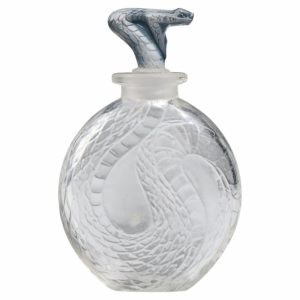 Clear glass perfume bottle with a coiled snake pattern and a snake-head stopper.