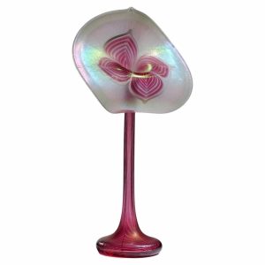 Pink iridescent glass lollipop with a flower pattern on a pink stem and round base.